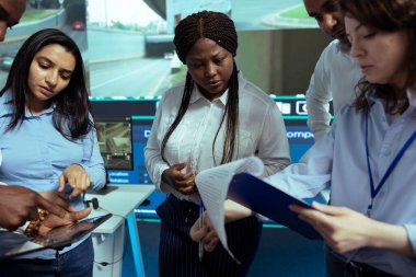 Kargo sevkiyatının lojistiğine bakan çeşitli çalışanlar izleme odasında teslimat gecikmelerini önlemek için paket takibi yapıyorlar. Operatör grubu uydu navigasyonuyla kamyonları takip ediyor..