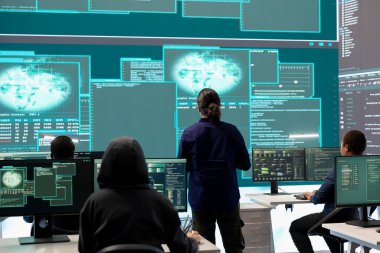 Hükümet bilgisayar korsanı, bilgisayar ağlarını güvence altına almak için gelişmiş teknolojiyi kullanarak teşkilat ofisindeki büyük ekrandaki bilgileri inceliyor. Siber güvenlik ve siber savaşa karşı savunma üzerine çalışıyorum..