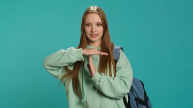 Portrait of assertive woman asking for timeout, doing hand gestures, feeling fatigued. Unhappy girl doing vehement pause sign gesturing, wishing for break, studio background, camera A clipart