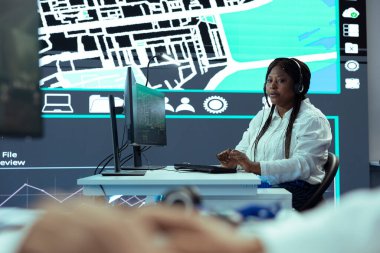 Afro-amerikan çağrı merkezi operatörü müşterilerin siparişlerini takip ediyor, teslimat kamyonunun yerini bildiriyor. Çalışan kuryeleri izlemek ve nakliye işini garantilemek için GPS radarı kullanır.