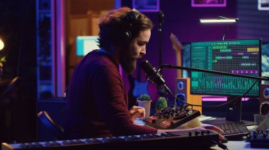 Ses mühendisi vokalleri kaydediyor ve mikrofonda şarkı söylüyor. Ana stüdyoda daw yazılımı ve karıştırma konsolu kullanıyor. Sanatçı karışık şarkıları dinliyor ve iyi bir akustik ses yaratıyor. Kamera A.