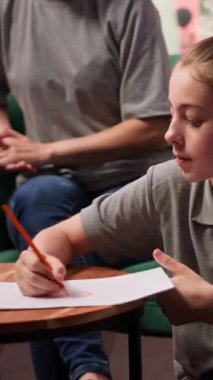 Terapi seansı sırasında, ergen bir kız davranış terapisi ve duygusal düzenlemelere yardımcı olmak için çizim yapıyor. Terapist ve anne onun zihinsel sağlığı için destek sağlıyor. Kamera A.