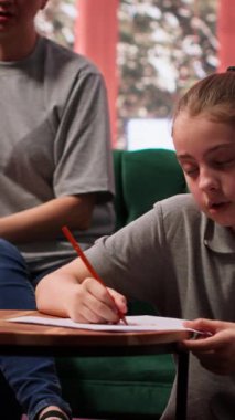 Genç kız, yaratıcı terapi seansının bir parçası olarak çizim yapıyor. Annesine ve terapistine danışmanlık, stres atmak ve duygusal yönetim için sanat eserlerini kullanmaya odaklanıyor. Kamera A.