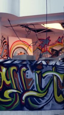Terk edilmiş binalara izinsiz giren şehir kaşiflerinin kullandığı terk edilmiş bir yeraltı deposunun dikey videosu. Grafiti sanatı ve dağınık döküntüler Urbex 'te hiç kimse yok.