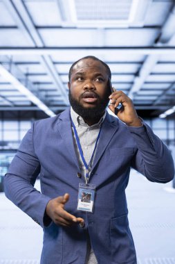 Üst düzey veri merkezindeki operasyonları idare yöneticisi denetliyor, telefon görüşmesi sırasında görevleri koordine ediyor. Sunucu merkezi yönetimi ve akıllı telefon aracılığıyla iletişim konusunda bilişim uzmanı