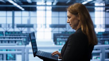 Sunucu merkezindeki sistem yöneticisi dizüstü bilgisayardaki kurtarma planını kontrol ediyor, enerji tüketimini izliyor. Bilgi işlem uzmanı veri merkezi çalışma alanında dizüstü bilgisayar kullanır, platformların optimum olarak çalıştığından emin olur, kamera A