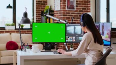 Renk derecelendirme yazılımının yanında krom anahtar fotokopi ekranı kullanarak yaratıcı bir proje video çekiminde çalışan kadın video düzenleyici. Ev işyeri verimliliği vurguluyor. Kamera B.
