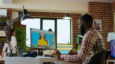 Erkek Afrikalı Amerikalı tasarımcı evdeki yaratıcı çalışma alanında fotoğraf düzenleme yazılımıyla çalışıyor. Grafik tasarım dünyasında verimlilik ve yenilik sağlamak için çift monitör kullanmak. Kamera A.