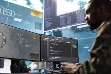 Modern bir operasyon merkezinde istihbarat ajanları gözetleme faaliyetlerini yönetiyor ve güvenlik protokollerini senkronize ediyorlar. Ordu güç üssü personeli ulusal çıkarları korumak için gerçek zamanlı verileri yorumluyor.