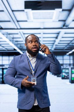 Bilgi işlem denetleyicisi son teknoloji veri merkezindeki operasyonları denetliyor, telefon görüşmesi sırasında görevleri koordine ediyor. Sunucu odasındaki Afrikalı Amerikalı adam sistemleri yönetiyor ve akıllı telefon aracılığıyla iletişim kuruyor.