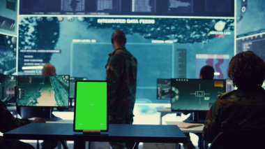 Askeri güç üssündeki bir tablette çalışan izole edilmiş yeşil ekran görüntüsü, askerler düşman saldırısına karşı tetikte olmak için güvenlik görüntülerini takip ediyorlar. Keşif için uydu sistemi kurduk. Kamera B.