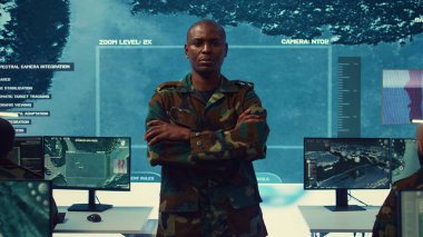 Portrait of confident military general wearing camo uniform in mission control center, overseeing operations regarding the national safety and protocol. Federal army base command post. Camera B. clipart