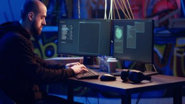 Hacker yeraltı sığınağında saklanırken müzik dinliyor ve PC virüsü kullanarak kurbanlardan veri çalıyor. Kulaklık takan düzenbaz programcı insanları fidye virüsü ve kamera B yüklemeye ikna ediyor.