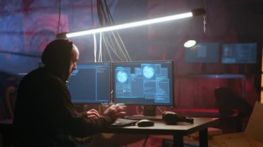 Hacker sisli karanlık bodrumda kötü niyetli kod çalıştırmak için yüksek teknoloji bilgisayar sistemi kullanıyor. Kaçak programcı, neon ışıklı suç sığınağında bilgisayar kullanarak yasadışı işler yapıyor. Kamera A