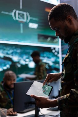 Hükümet istihbarat subayları operasyon odasında gözetleme faaliyetlerini yönetiyor, askerlere yardım etmek için istihbarat topluyorlar. Ulusal çıkarların korunması için gerçek zamanlı veriler analiz ediliyor.