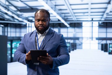 Sunucu merkezindeki bilgili programcı tablet kullanarak yeni sipariş edilmiş depolama birimleri kuruyor. Veri merkezinde çalışan bilişim uzmanı iş alanı konut depolama altyapısını düzenliyor