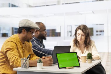 Real estate agents meeting with a client next to isolated mockup on tablet, experts offering the architectural blueprints before securing a leasing contract. Woman investing in property. clipart