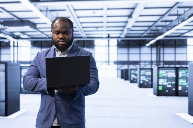 Veri merkezinde yürüyen teknisyenler, sistem performansını dizüstü bilgisayarla izlemek, darboğazları tanımlamak ve verimliliği artırmak için optimizasyonları uygulamak. Sunucu merkezi çalışanı sorun çıkarma hatası