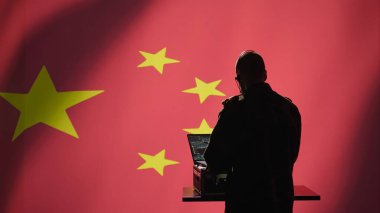 Kontrol merkezindeki askeri harekat subayı ordu istihbarat analistlerinden cephedeki birliklere bilgi aktarıyor. Telsiz iletişim operatörü kamuflaj üniformalı mikrofon ve kamera B ile konuşuyor.