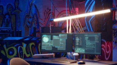 Kapüşonlu hacker grafiti resimleriyle dolu neon ışıklı yeraltı sığınağına geliyor. Siber suçlular renkli bodruma giriyor, sunucuları çökertebilen senaryolar üzerinde çalışmaya başlıyor, kamera B