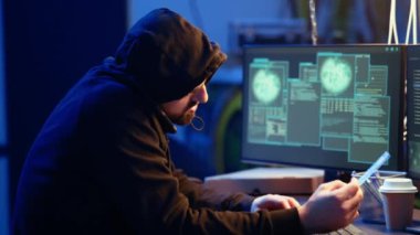 Terk edilmiş depodaki bilgisayar korsanı ortağıyla telefonda konuşuyor. Sahtecilik tekniği kullandıktan sonra veri çalıyor. Meslektaşıyla telefonda konuşan bir adam, kullanıcıları kandırarak bilgi sızdırıyor, kamera A