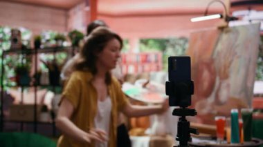 Kadın sanatçı, kırsal sanat eserlerinde kullanılan ürün ve teknikleri sunmak için çevrimiçi sınıfa ev sahipliği yapıyor, öğretim videolarını internette kaydediyor. Ressamlardan oluşan bir ekip, e-öğrenme ve sanat eğitimi için yüksek lisans yapıyor. Kamera B.