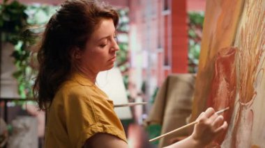 Ressam, sanat atölyesindeki modern boya fırçalarını kullanarak bir sanat eseri için doğal köy dekorasyonlarından ilham alıyor. Sanat sürecinde motivasyon ve yaratıcılıkla çalışmak. Kamera A.