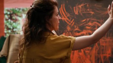 Ressam, son sanat eserinde parmak boyama tekniğiyle çalışır. Çağdaş sanat stüdyosu yaratıcılıkla uğuldar. Sanatçı canlı renkler ve modern boya tasarımı kullanır. Kamera A.