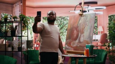 Afrikalı Amerikalı ressam, başyapıtının resmini sosyal medyada yayınlayarak içerik yaratımı için daha iyi bir imaj yaratıyor. Kendi promosyonundan emin. Kamera B.