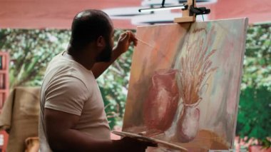 Ressam, bir tuvale belli bir teknikle suluboya boya boya uygular ve çarpıcı bir sanat eseri yaratır. Sanatçı boş zamanlarında canlı renkler ve fırça darbeleri efektleri kullanır. Kamera A.