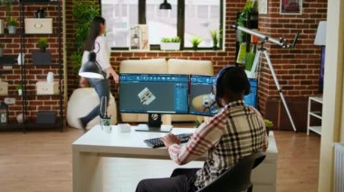 Afrika kökenli Amerikalı endüstriyel tasarımcı CAD yazılımında çalışıyor ve evde müzik dinliyor, birden fazla iş yapıyor. Mühendis endüstriyel projeler için dijital aletler ve 3D modelleme kullanıyor. Kamera A.