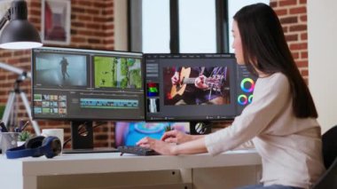 Freelancer Asyalı kadın video yapımcısı bir film projesinde çalışıyor, çift monitörlü çoklu görev, yazılım düzenleme ve çalışma alanında renk çarkı. Film kurgu endüstrisi. Kamera B.