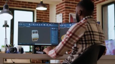 Afrikalı Amerikalı endüstriyel tasarımcı yaratıcı bir stüdyoda prototipler üzerinde çalışıyor. 3D modelleme ve CAD yazılımı ile uzaktan kumandalı teknoloji kullanımı, teknik hassasiyet için endüstriyel araçlar. Kamera B.