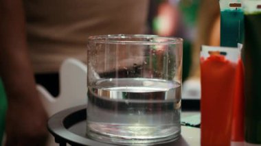 Afrikalı Amerikalı sanatçı boya fırçasıyla tuvale akrilik boya uyguluyor, sanat galerisi için bir başyapıt yaratma yeteneğini gösteriyor. Profesyonel malzemelerle çalışıyor. Kamera A.