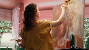 Kırsal bir atölyede sanatçı, rengarenk bir başyapıt yaratmak için palet üzerine çeşitli suluboya boyalar karıştırır. Fırçayla resim yapan ve yeteneğini, sanat eserlerini sergileyen bir kadın. Kamera A.