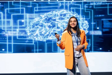 Teknolojik etkinlikte sunucu sunucusu suni zeka teknolojisinin etkisini açıklıyor. Açılış konuşması sırasında AI ile ilişkili risk ve tehditler sunan iyimser bir uzman