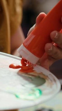 Kırsal bir atölyede, ressam bir palette suluboya boyayı karıştırarak tuval üzerinde bir başyapıt yaratır. Fırçayla resim yapan yetenekli bir kadın yaratıcılığını ve sanat eserlerini gösteriyor.