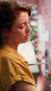 Dikey Video Ressamı, sanat atölyesindeki modern boya fırçalarını kullanarak bir başyapıt için doğal köy dekorasyonlarından ilham alıyor. Sanat süreci için motivasyon ve yaratıcılıkla çalışmak