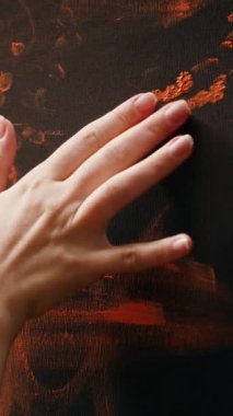 Bir sanat stüdyosunda, sanatçı parmak boyalı bir başyapıt yaratmak için suluboya boya boya boya kullanır. Yetenekli ressam, el izleriyle rengarenk bir sanat yaratma ilhamı gösteriyor.