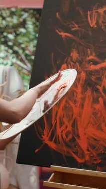 Dikey Video Ressamı son sanat eserinde parmak boyama tekniğiyle çalışıyor. Çağdaş sanat stüdyosu yaratıcılıkla dolup taşıyor. Sanatçı canlı renkler ve modern boya tasarımı kullanır.