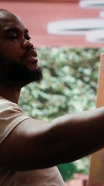 Dikey Video Afrikalı Amerikalı ressam bir video ve kişisel reklam başyapıtı kaydediyor, sanatın tanıtımı için sosyal medyayı kullanıyor ve bir markalaşma yaratıyor. Sanatsal süreç belgeleniyor