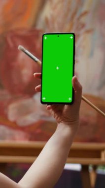 Dikey Video Genç kadın kroma anahtar ekranına ve kırsal başyapıtına bakıyor, sanat galerisi için yaptığı resimden gurur duyuyor ve kendine güveniyor. Sanatçı boş zamanlarında hobisinin keyfini çıkarıyor
