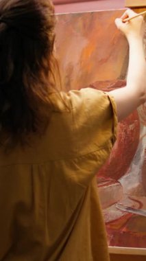 Dikey Video Yeteneği olan bir kadın palete renkli boyalar çizerek atölyedeki belli bir resim tekniğiyle güzel, yaratıcı bir resim yaratıyor. Suluboya karıştıran sanatçı