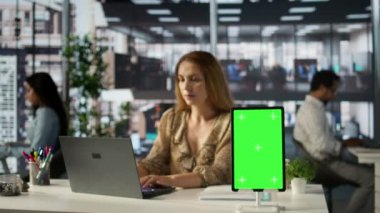 Genel müdür raporlu bir belgeyi gözden geçiriyor ve şirketin verimliliğini sağlamak için performans ölçümlerini değerlendiriyor. Bilgili kararlar almak için laptopunu kullanıyor. Kamera B.