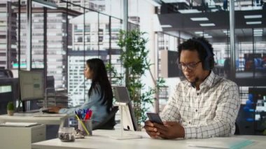 Afrika kökenli Amerikalı genel müdür tahminleri değerlendirirken kulaklıkla müzik dinliyor, masasında kendini rahat ve çoklu görev başında hissediyor. Veri analisti hedeflere, strateji planlamasına odaklanıyor. Kamera B.