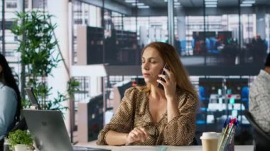 Girişimci onun sabit telefon görüşmesini önemli bir şirket iletişimi için kullanıyor. Kadın, dizüstü bilgisayarı üzerinde çalışırken kaynak tahsisi, finansal planlama ve son teslim tarihi yönetiminden bahsediyor. Kamera A.