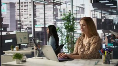 Şirket masasında oturan kendine güvenen yetenekli girişimci, iş büyümesini tahmin etmek için dizüstü bilgisayarını kullanıyor. Finansal planlamayı yönetmek ve hedeflere ulaşmak. Kamera B.