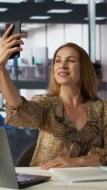 Dikey video girişimcisi işe ara verir ve bir şirkette bazı resimler çeker, iş görevleri üzerinde çalışır ve akıllı telefonunu fotoğraf çekmek için kullanır. Kendine güvenen bir iş kadını yakaladı.