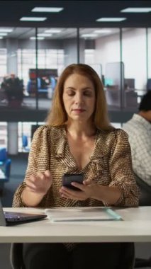 Dikey videolu profesyonel kadın iş stratejisi ve müşteri hedefleri hakkında telefon görüşmesi yapıyor. Müzakere, girişim içinde karar verme ve mali planlamayı vurguluyor