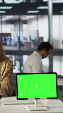 Dikey video Yöneticisi, aylık raporları kopya alan ekranıyla analiz ediyor, strateji planlaması ve finansal tahminler üzerinde çalışıyor. İş geliştirme uzmanı karar analizlerini inceliyor